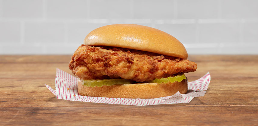Chick-fil-A® Chicken Sandwich on printed paper on a wooden table