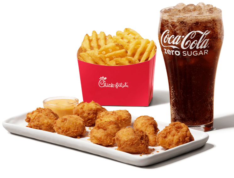 Chick-fil-A® Nuggets on a plate, with Chick-fil-A® Waffle Potato Fries and a glass of Coca-Cola® Zero Sugar